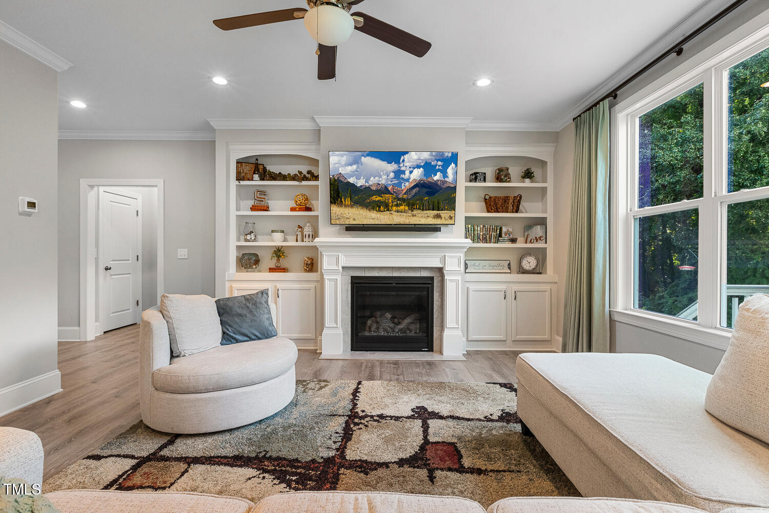 830 Wilbon Road Holly Springs, NC 27540 - Photo 8 of 60 a living room with furniture a flat screen tv and a fireplace