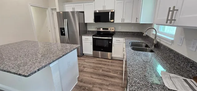 a kitchen with stainless steel appliances granite countertop a sink stove and refrigerator