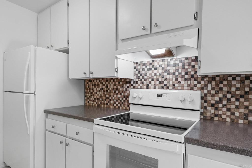 4891 Collwood Boulevard, Unit B San Diego, CA 92115 - Photo 19 of 34 a kitchen with granite countertop white cabinets and refrigerator