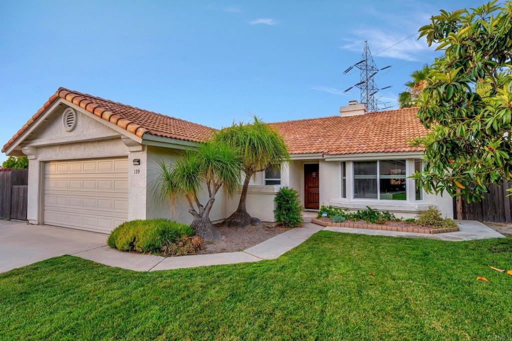 a front view of a house with a garden and plants