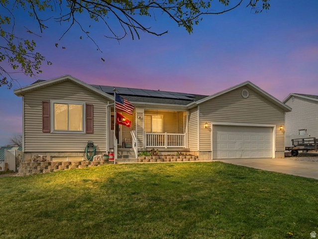 382 770 South Tooele, UT 84074 - Photo 1 of 1 Single story home featuring roof mounted solar panels, covered porch, an attached garage, concrete driveway, and a yard