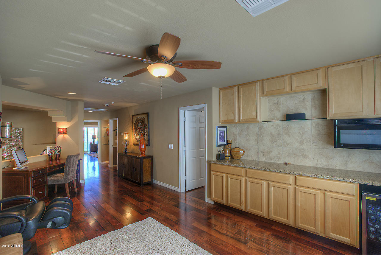 7532 East Alameda Road Scottsdale, AZ 85255 - Photo 11 of 27 a kitchen with stainless steel appliances granite countertop a sink and wooden floors