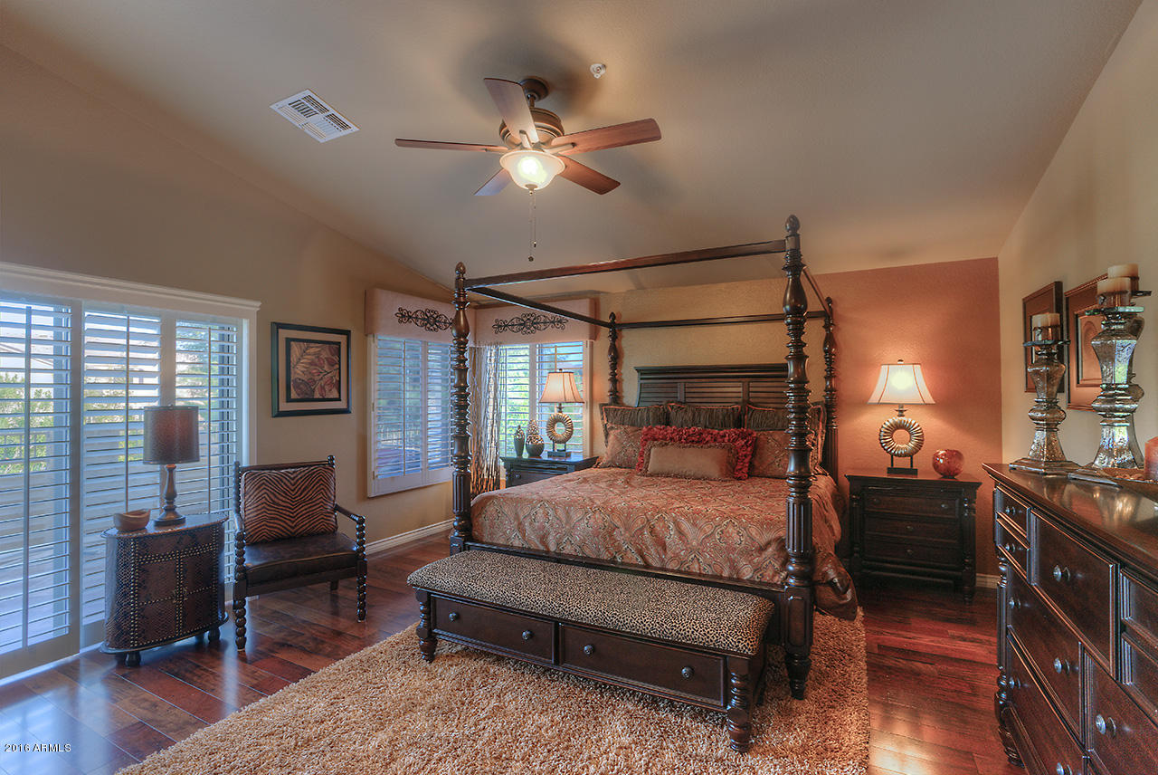 7532 East Alameda Road Scottsdale, AZ 85255 - Photo 13 of 27 a bedroom with a bed and wooden floor