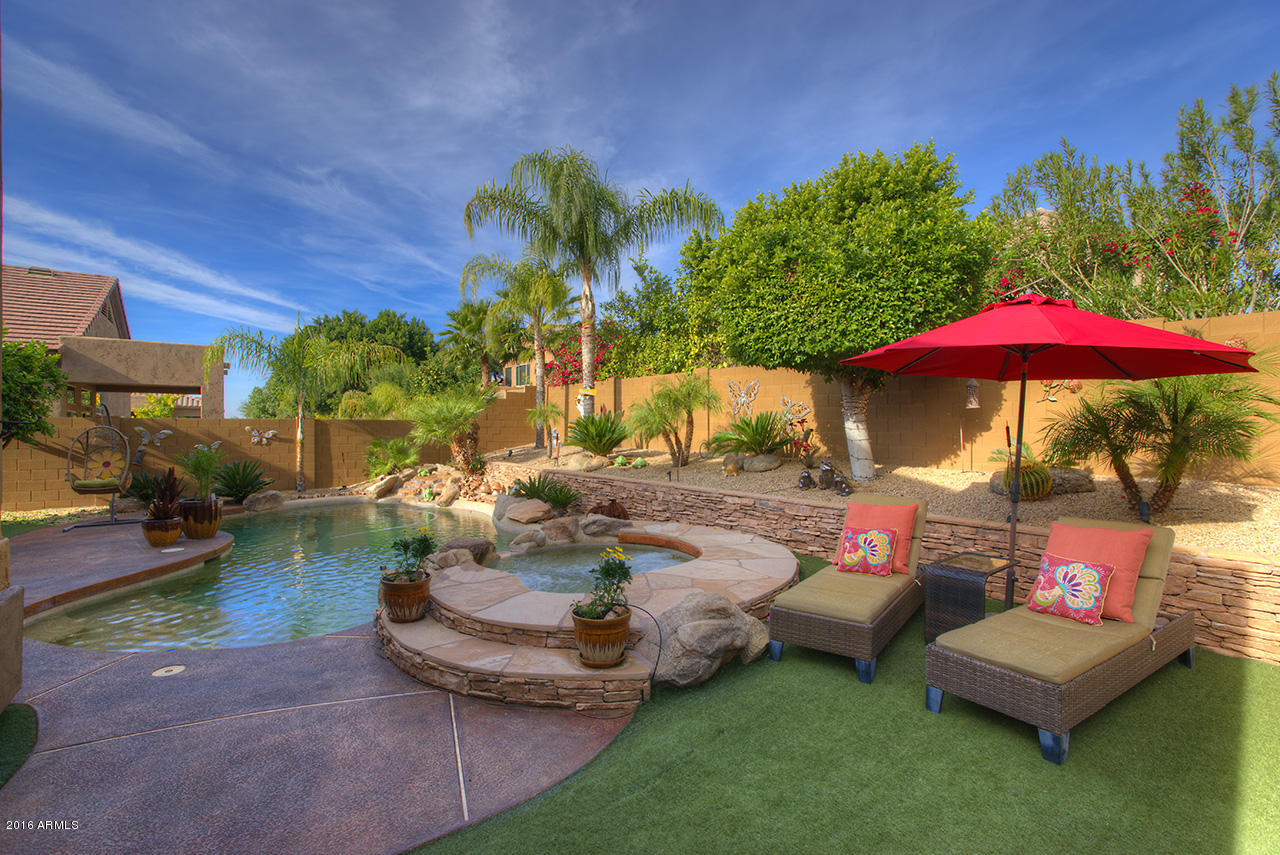 7532 East Alameda Road Scottsdale, AZ 85255 - Photo 27 of 27 a view of a backyard with lawn chairs under an umbrella