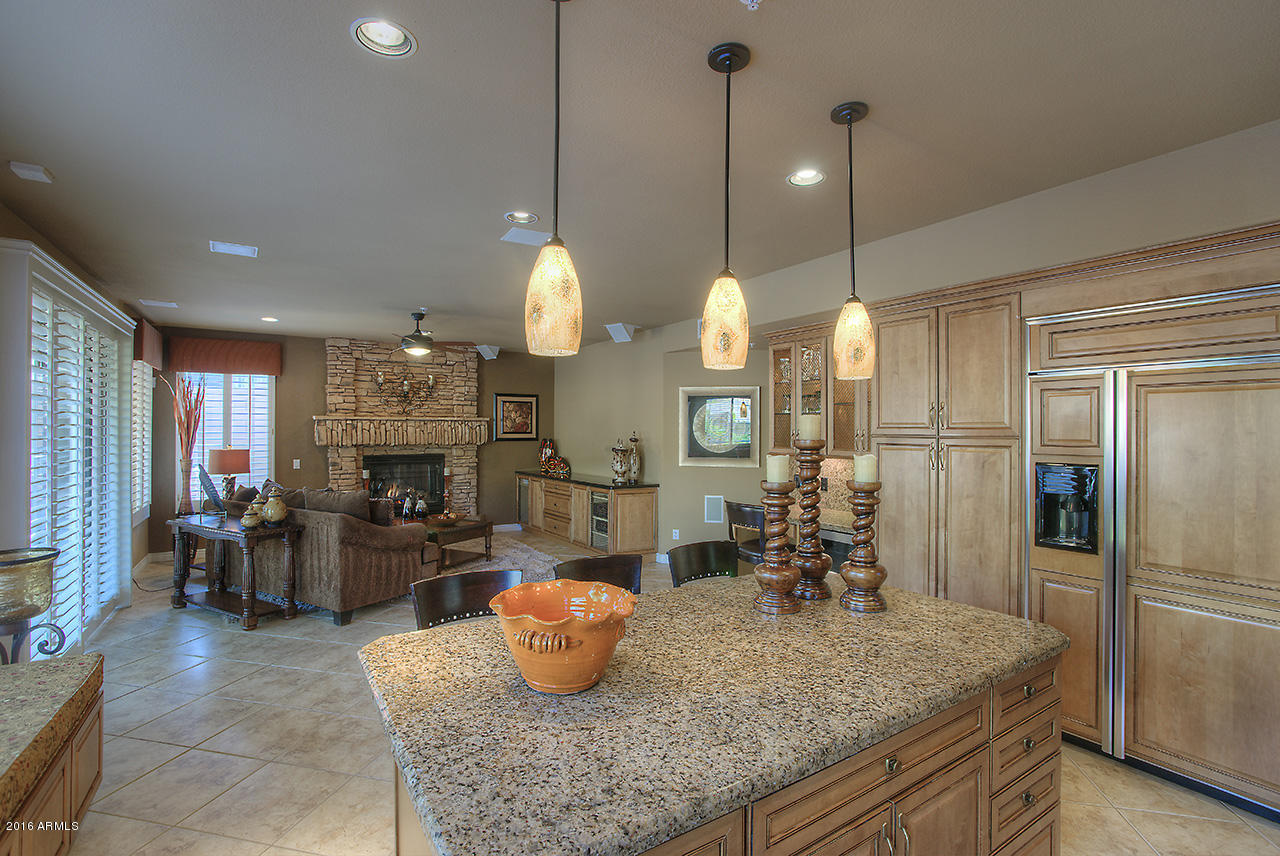 7532 East Alameda Road Scottsdale, AZ 85255 - Photo 6 of 27 a kitchen island with stainless steel appliances granite countertop a stove refrigerator and cabinets