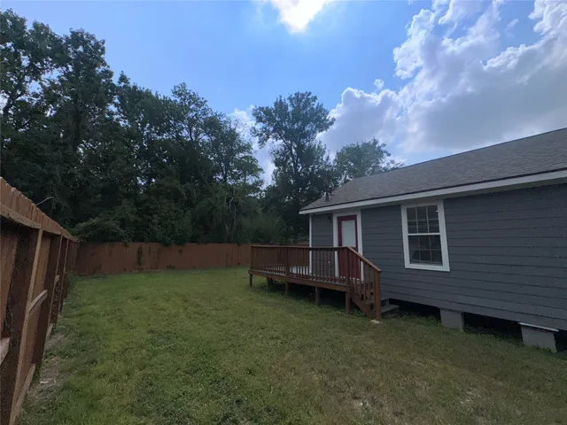 a view of a backyard with plants and a large tree
