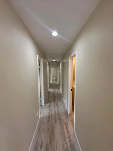 a view of hallway with wooden floor