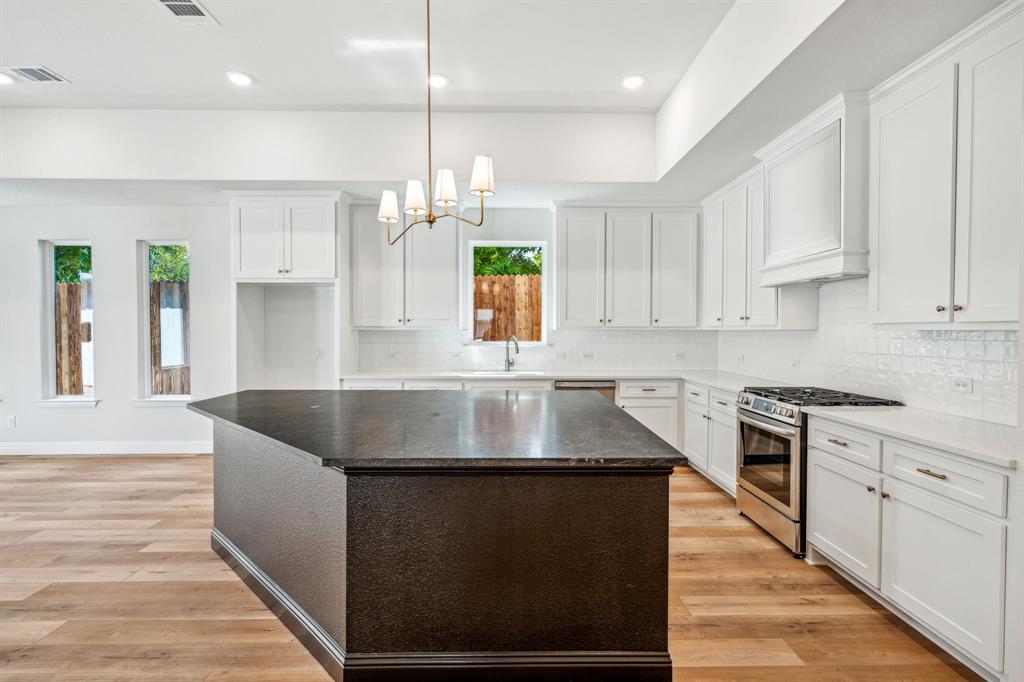 122 John Street Aledo, TX 76008 - Photo 9 of 33 a kitchen with stainless steel appliances granite countertop a sink a stove and a refrigerator