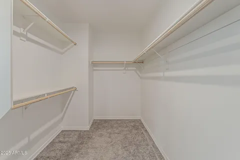 a view of an empty room with chandelier fan and fire place