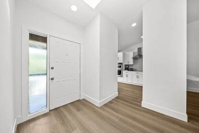 an empty room with wooden floor and white walls