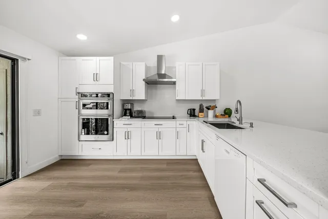 a kitchen with stainless steel appliances a white cabinets and stove top oven