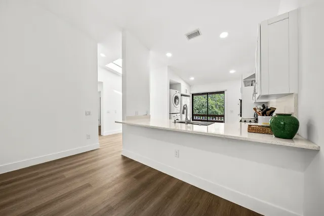 an empty room with wooden floor and window