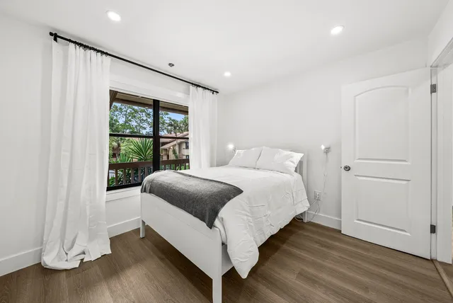 a bedroom with a bed and a window