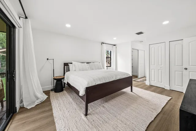 a bedroom with a bed and a wooden floor