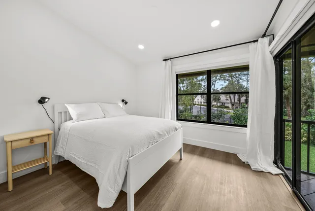 a large white bed sitting in a room next to a window
