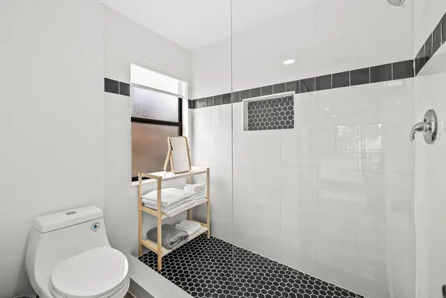 a bathroom with a toilet and a shower