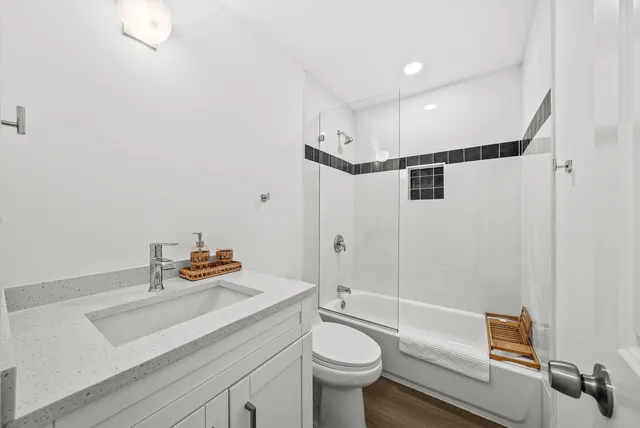 a bathroom with a sink mirror vanity and toilet