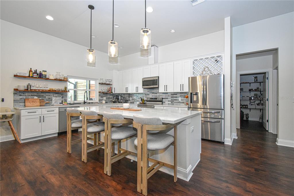 7890 Southwest 129th Avenue Cedar Key, FL 32625 - Photo 9 of 45 a kitchen with stainless steel appliances kitchen island granite countertop a table chairs and a refrigerator