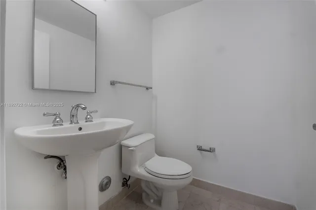 a bathroom with a sink toilet and a mirror