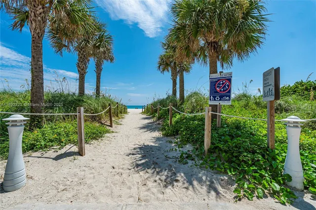 a view of a bench in the middle of a beach