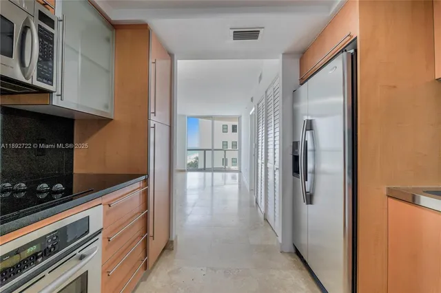 a view of a hallway with wooden floor and living room
