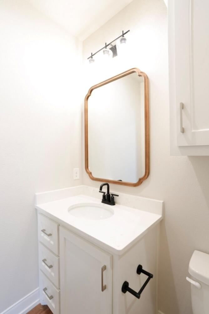 712 East 19th Street Wolfforth, TX 79382 - Photo 19 of 23 a bathroom with a sink vanity and a mirror