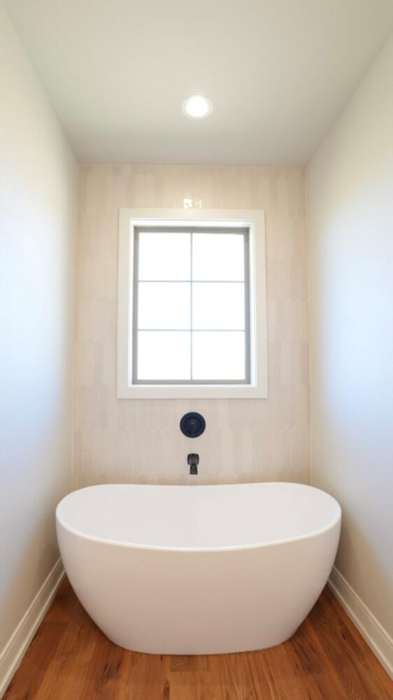 712 East 19th Street Wolfforth, TX 79382 - Photo 10 of 23 a white bath tub sitting in a bathroom