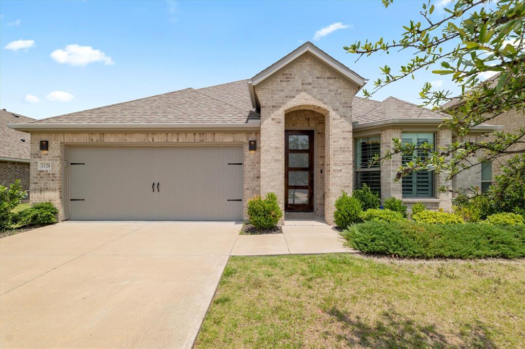 1120 Flamingo Road Forney, TX 75126 - Photo 1 of 1 French country style house featuring brick siding, roof with shingles, an attached garage, and concrete driveway