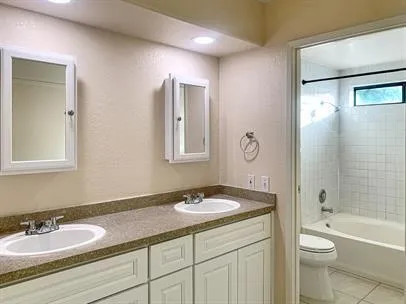 a bathroom with a granite countertop sink toilet a mirror and shower