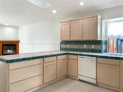 a kitchen with white cabinets and sink