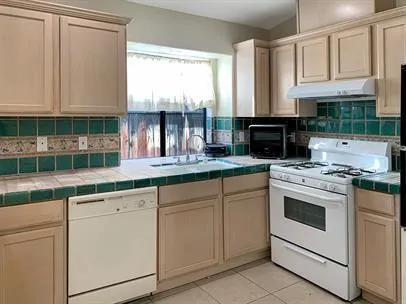 a kitchen with granite countertop white cabinets and white appliances