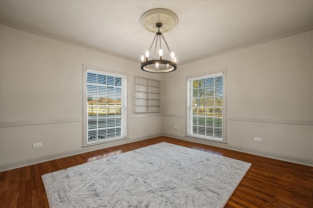 601 North Main Street Leonard, TX 75452 - Photo 17 of 34 Empty room featuring crown molding, suspended lighting, built in features, and dark wood-type flooring