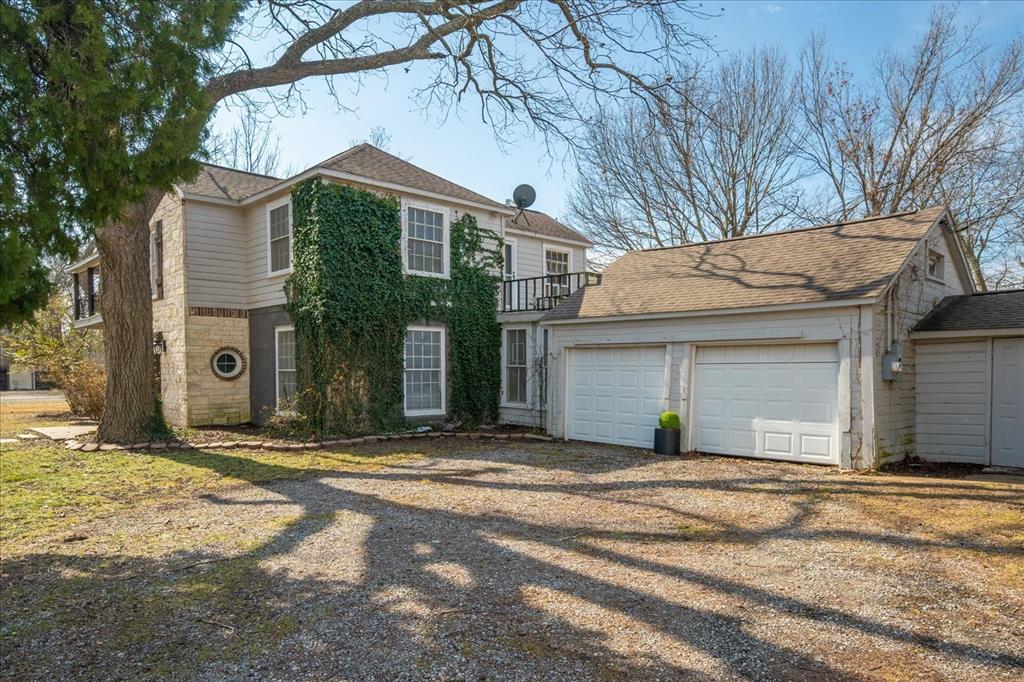 601 North Main Street Leonard, TX 75452 - Photo 27 of 34 View of front of property with driveway, a balcony, an attached garage, and a shingled roof