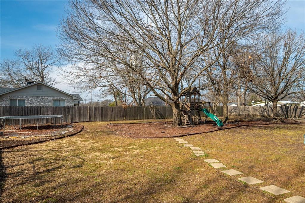 601 North Main Street Leonard, TX 75452 - Photo 28 of 34 Fenced backyard with a playground and a trampoline