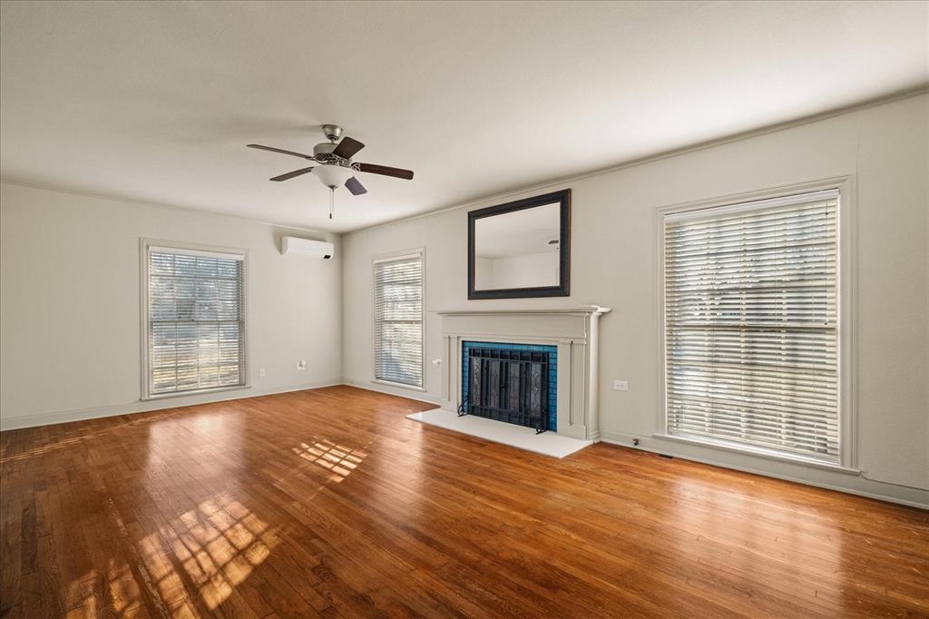 601 North Main Street Leonard, TX 75452 - Photo 9 of 34 Unfurnished living room with ceiling fan, light wood-style floors, and a fireplace with flush hearth