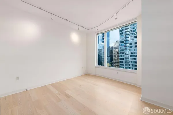 a view of a big room with windows and chandelier fan