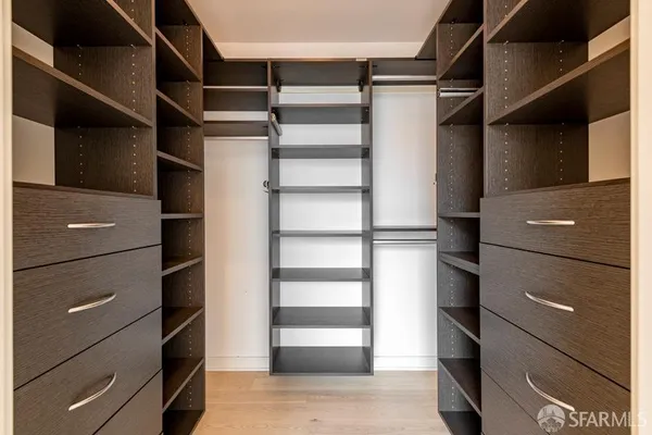 a view of walk in closet with empty racks