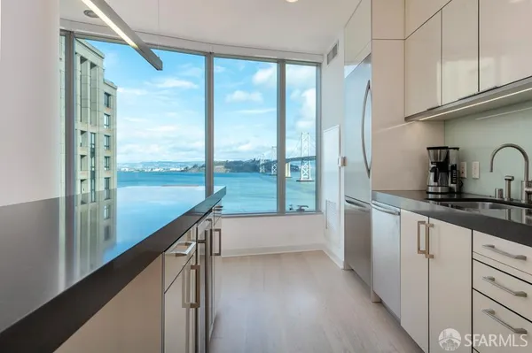 a kitchen with a large window a sink and cabinets