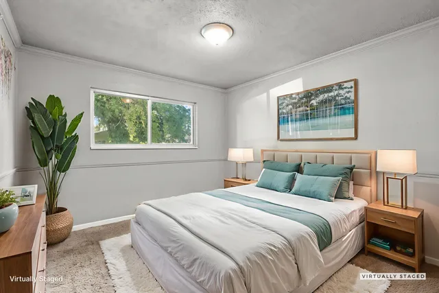 a bedroom with bed and a potted plant