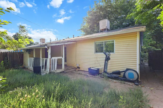 a view of backyard with potted plants and wooden fence