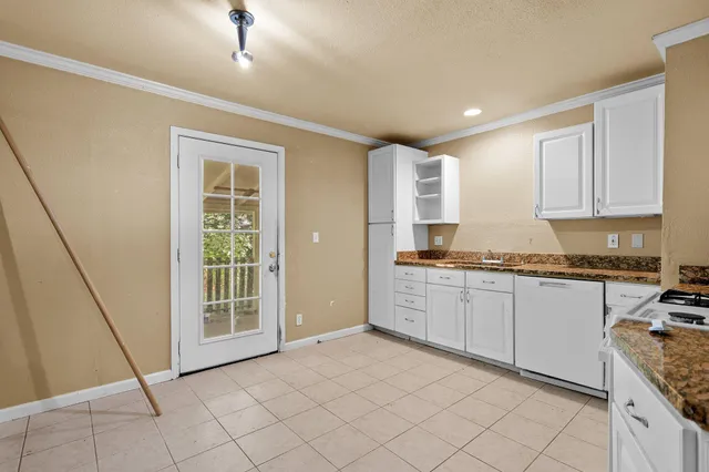 a kitchen with granite countertop a sink and a stove top oven