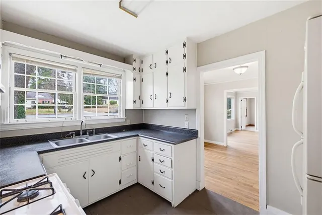a kitchen with granite countertop white cabinets and a sink