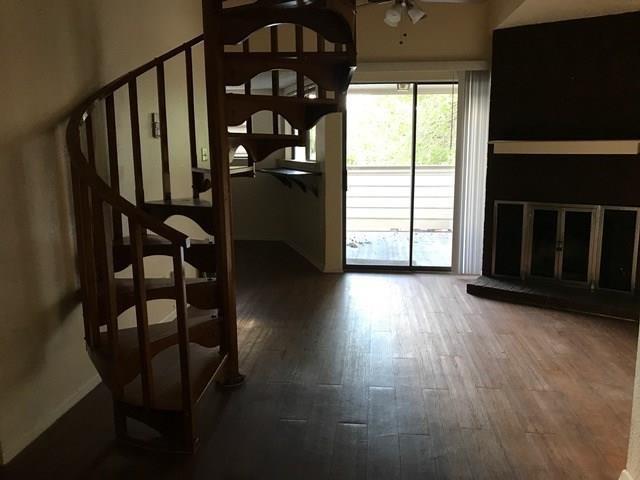 2500 Burleson Road, Unit 312 Austin, TX 78741 - Photo 1 of 6 A spacious living area presents a graceful spiral staircase, rich hardwood flooring, and an inviting fireplace.