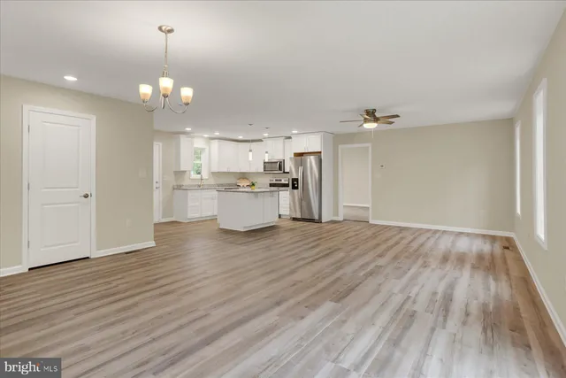 a view of a kitchen with a wooden floor and chandelier