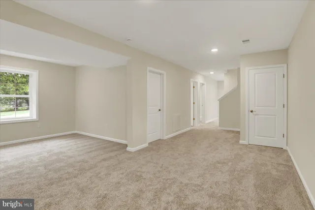 an empty room with windows and closet