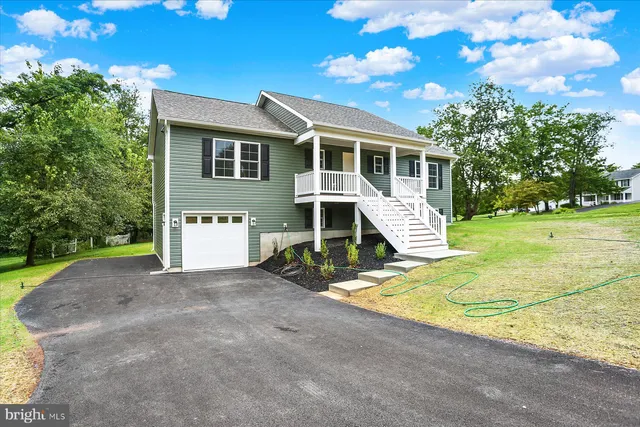 a view of a house with a yard and potted plants