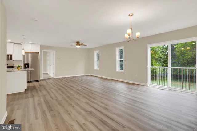 a view of empty room with wooden floor and stove