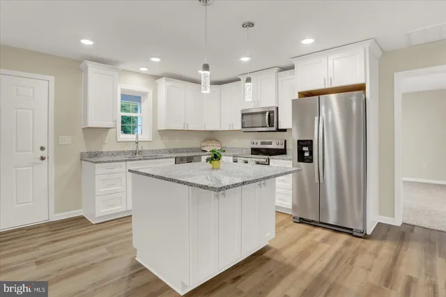 a kitchen with stainless steel appliances granite countertop a white stove top oven and refrigerator
