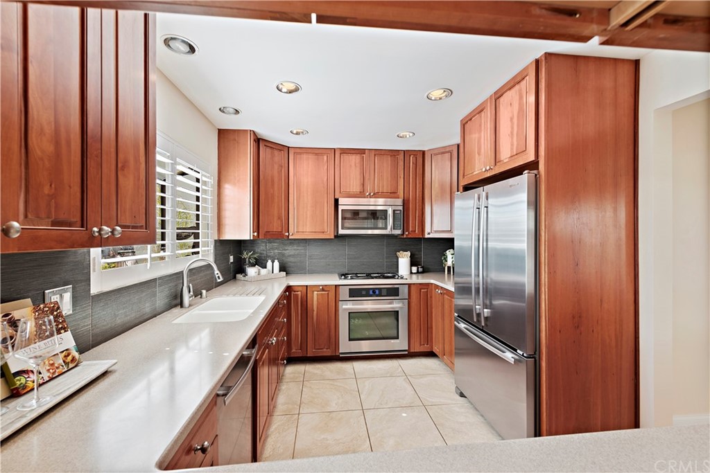 35232 Camino Capistrano, Unit 6 Dana Point, CA 92624 - Photo 10 of 25 a kitchen with stainless steel appliances granite countertop a refrigerator a sink dishwasher a stove with wooden cabinets