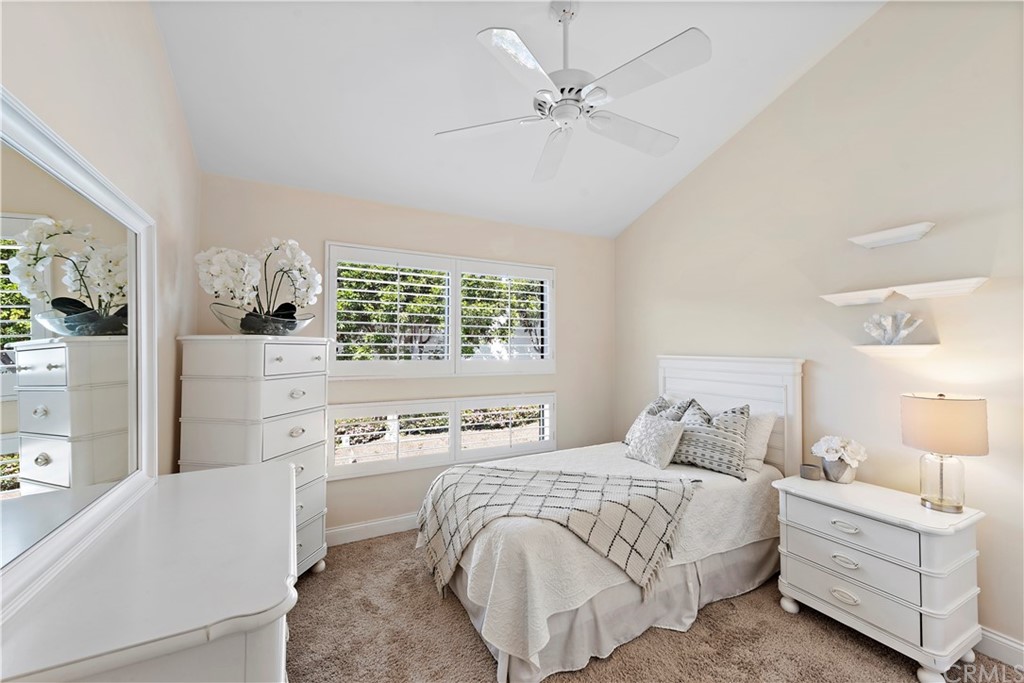 35232 Camino Capistrano, Unit 6 Dana Point, CA 92624 - Photo 16 of 25 a bedroom with a white bed and a chandelier